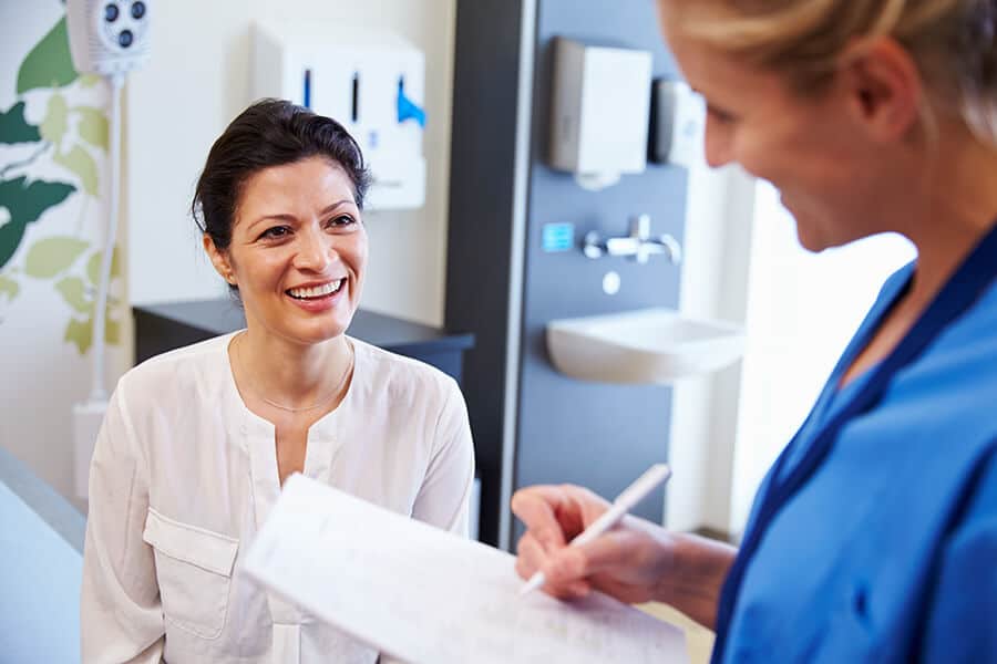 médico consultando con una mujer sobre anticonceptivos