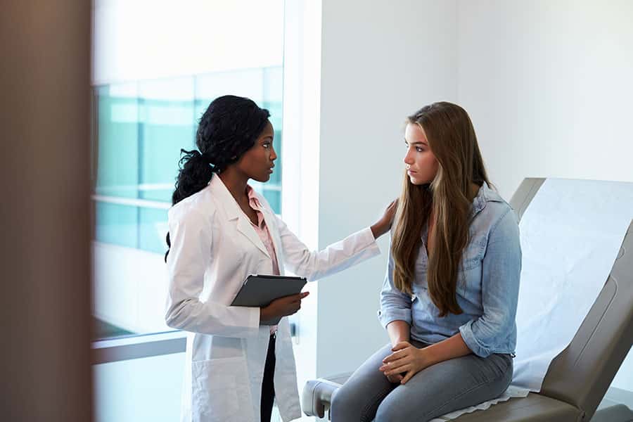 Médico y paciente discutiendo el dolor después de la vida.