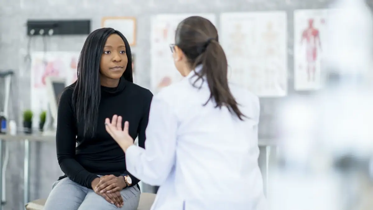 Doctor hablando con una mujer negra sobre los fibromas.