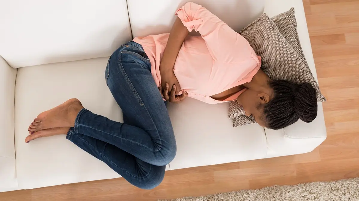 woman feeling bloated on a couch