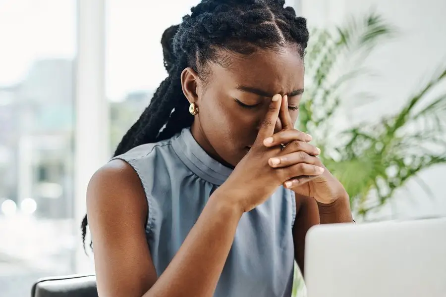black woman with fibroids stressed in an office
